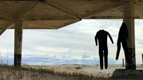 Drying laundry, wetsuit hanging on the beach of sea. Spbd. nobody, no people Stock-Footage 136347255