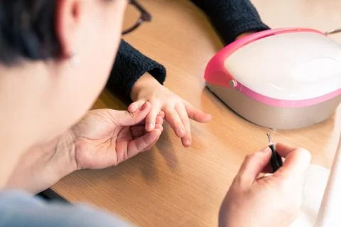 Drying nail polish under led lamp at home Stock Photos
