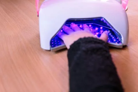 Drying nail polish under led lamp Stock Photos