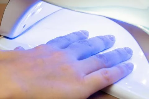 Drying nails after applying varnish in a special ultraviolet dryer Foto stock