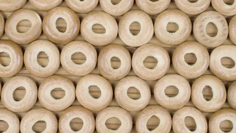 Drying or mini round bagels on wooden background. Video stock 152817600
