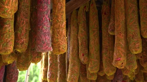 Drying pepper pods hanging in nets, preserving flavor for traditional culinary Stock Footage 333521156