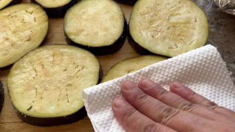 Drying Sliced Eggplants with Paper Towels Before Frying Stock Footage 345320740