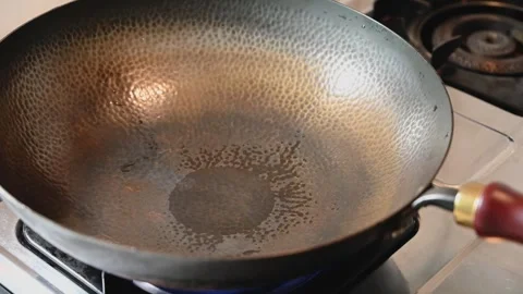 Drying a Traditional Iron Wok over a Gas Stove Flame Stock Footage 346305346