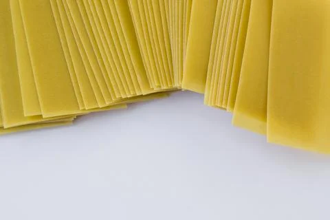 Dry,uncooked lasagna sheets lined up on a white background Stock Photos
