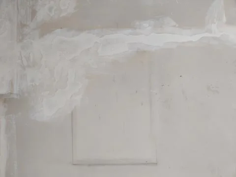 Drywall square patch repair on rough plaster wall Stock Photos