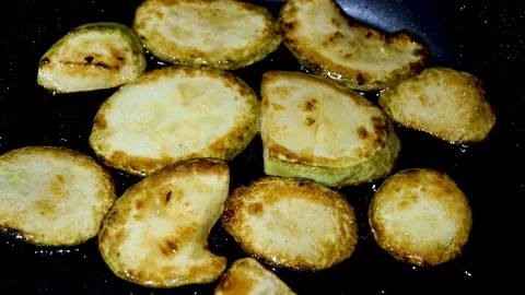 DSC Slices of zucchini fried on the second side in a frying pan Stock Footage 111277582