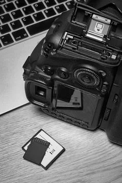 DSLR camera and memory cards on a table next to the computer, top view Stock Photos