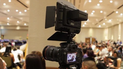 DSLR camera with LED light filming a graduation ceremony Stock Footage 122525345