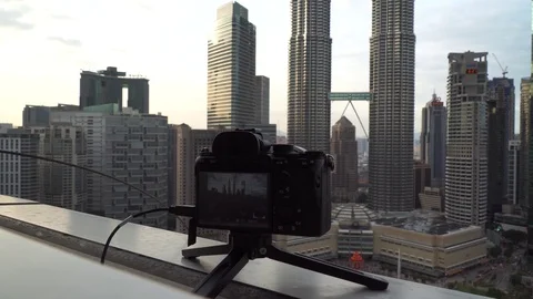 DSLR or mirrorless camera capturing or recording time lapse of Kuala Lumpur skyl Stock Footage 105327747