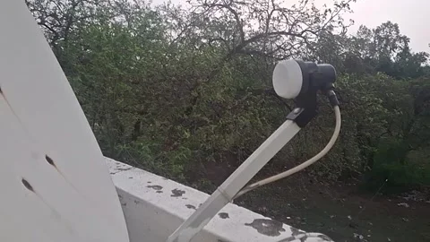 A DTH receiver and dish receive satellite signals, decoding digital TV Video stock 306594156