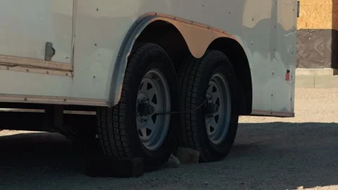 Dual Axle Utility Trailer Wheels Parked on Gravel Lot Stock Footage 330918674