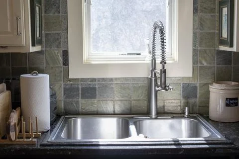 Dual Basin Kitchen Sink with Spring Neck Faucet and Window Stock Photos