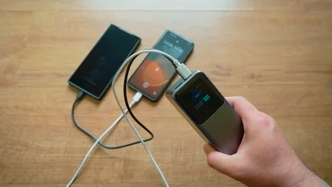 Dual charging from power bank using two cables portable charger powering two Stockbeeldmateriaal 339344157