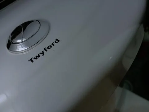 Dual silver push button on white Twyford water closet. Stock Photos