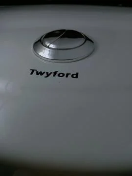 Dual silver push button on white Twyford water closet. Stock Photos