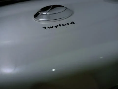 Dual silver push button on white Twyford water closet. Stock Photos