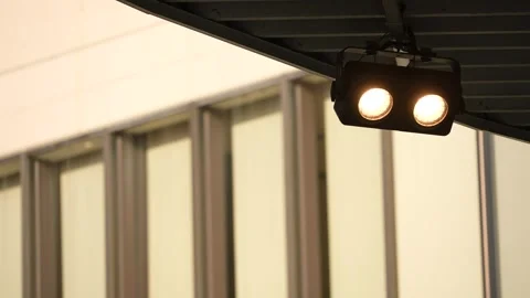 Dual warm spotlight mounted under eave with blurred building Stock Footage 346332960