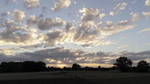 Duality of sunset landscape with dark lighted meadows and cornfields in Stockbeeldmateriaal 136484834