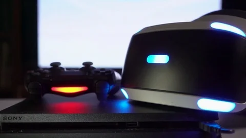 DualShock 4 controller and VR headset on Sony PlayStation 4 slim game console Stock Footage 76399582
