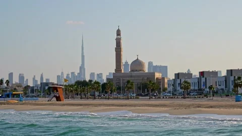 Dubai beach with waves, palm trees, and a mosque near the shore. The city Stock Footage 311201502