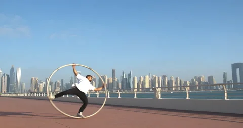 Dubai Marina in the background of a man doing wheel gymnastics, vacation, 4k Stock Footage 151692537