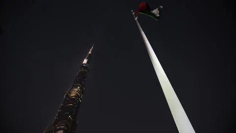 Dubai, UAE - 10 October 2024: Burj Khalifa and UAE flag at night in Dubai Stock Footage 304859892