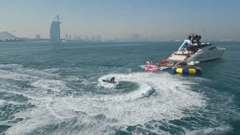Dubai, UAE - 3 20 2023: A drone flies over people riding jet skis on the sea Stock Footage 249506153