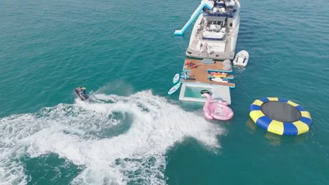 Dubai, UAE - 3 20 2023: A drone flies over people riding jet skis in the sea Stock Footage 253973084