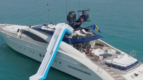 Dubai, UAE - 3 20 2023: A drone flies around a luxury private yacht standing at Stock Footage 255754790