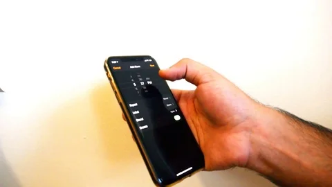 Dubai / UAE - AUGUST 30, 2019: Man hand is setting alarm in smartphone. Stock Footage 115770860