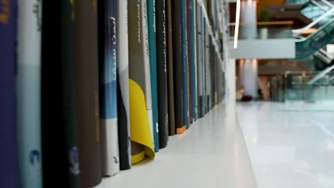 Dubai, UAE - June 19, 2024: Close-up of books on shelves in the Library. Stock Footage 279877505
