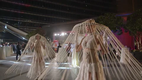 DUBAI, UAE - MARCH 7, 2020: Two girls in pearl and white feather costumes spin Stock Footage 134899109