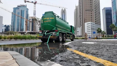 DUBAI, UAE - MAY 14, 2026: Municipal workers using water tankers and pumps .. Stock Footage 334921296