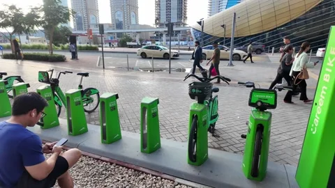 DUBAI, UAE - MAY 15, 2026: People walking and cycling in the modern urban d.. Stock Footage 334922316