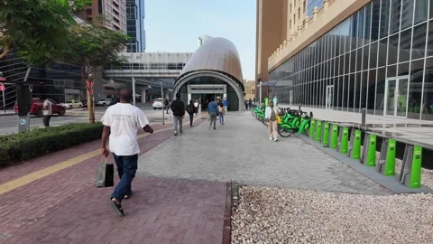 DUBAI, UAE - MAY 15, 2026: People walking and cycling in the modern urban d.. Stock Footage 334922373