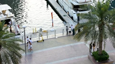 Dubai, UAE - May 24, 2024: Tourists walking on Dubai marina walk. Video stock 279877649