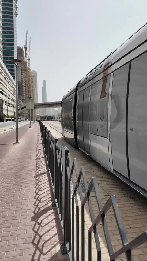 Dubai, UAE - May 26, 2026: Dubai Marina Tram passing through modern skyscra.. Stock Footage 335695567