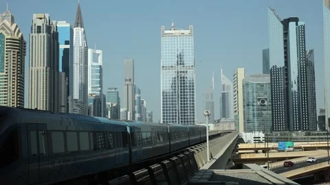 Dubai, UAE - November 01, 2025: Train passing through a modern city with sk.. Stock Footage 333514246