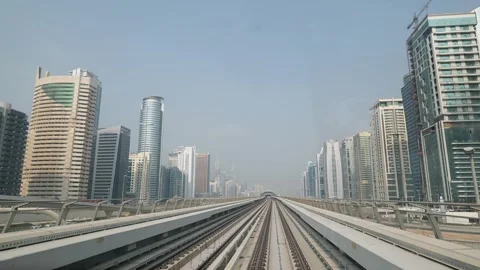 Dubai, UAE - October 28, 2025: Metro train tracks leading through a modern .. Stock Footage 333513998