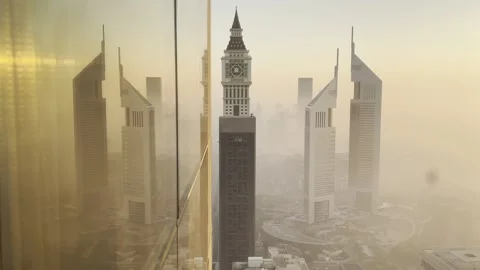 Dubai, UAE: Reflection of cityscape with rising sun and morning fog at dawn, 4K Stock Footage 305910236