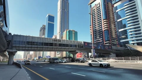 Dubai's Sheikh Zayed Road on a sunny morning, with traffic and towering Stock Footage 298307230