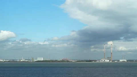 Dublin Bay with Poolbeg chimneys against a blue sky as airplane flies accross Stock Footage 101647981