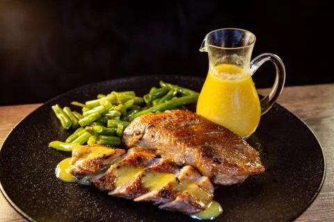 Duck breast with string beans and orange sauce Stock Photos