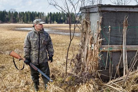 A duck hunter stands next to an old shelter Stock Photos
