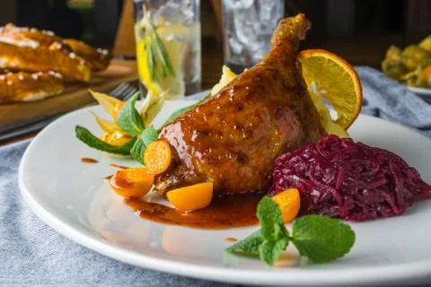 The duck leg on a rustic table in a cozy pub Stock Photos