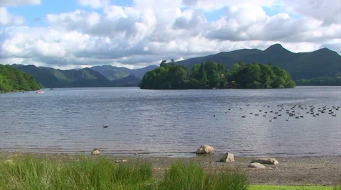 Ducks on the lake from the beach, clouds over the mountains, wide Stock Footage 39996472