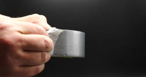 Duct tape being held by construction worker peeling tape isolated on black Vidéo 205438813