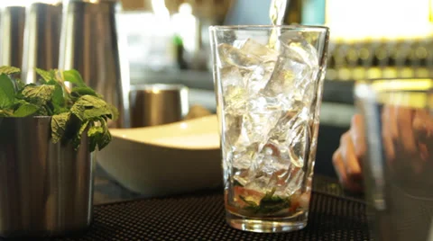 A dude prepares the drink by mixes something in a glass tumbler Stock Footage 35405238