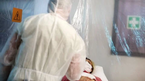Due persone si prendono cura di una donna con un viruso su una culla. Stock Footage 143353628